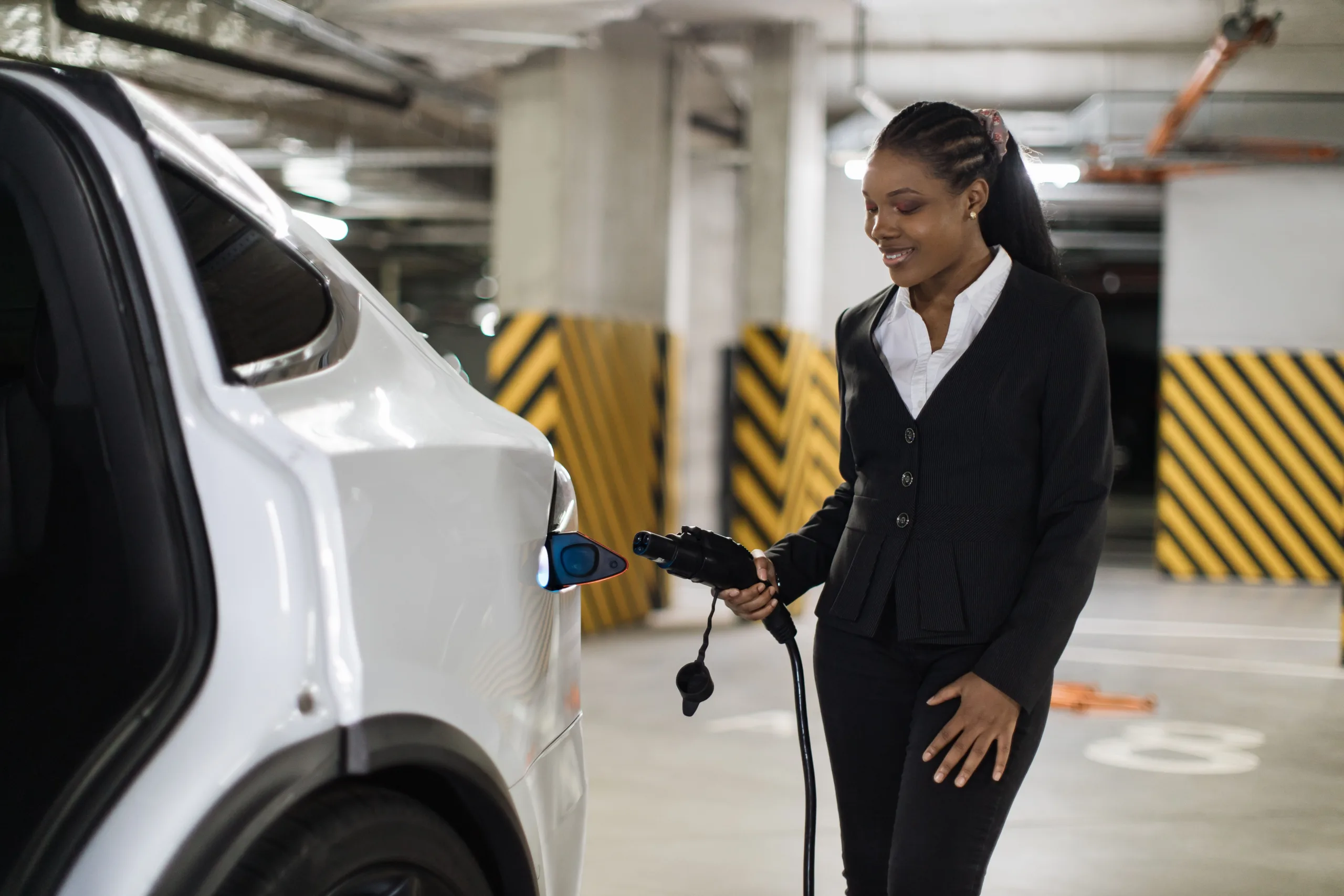 Driver plugging an electric car in to charge