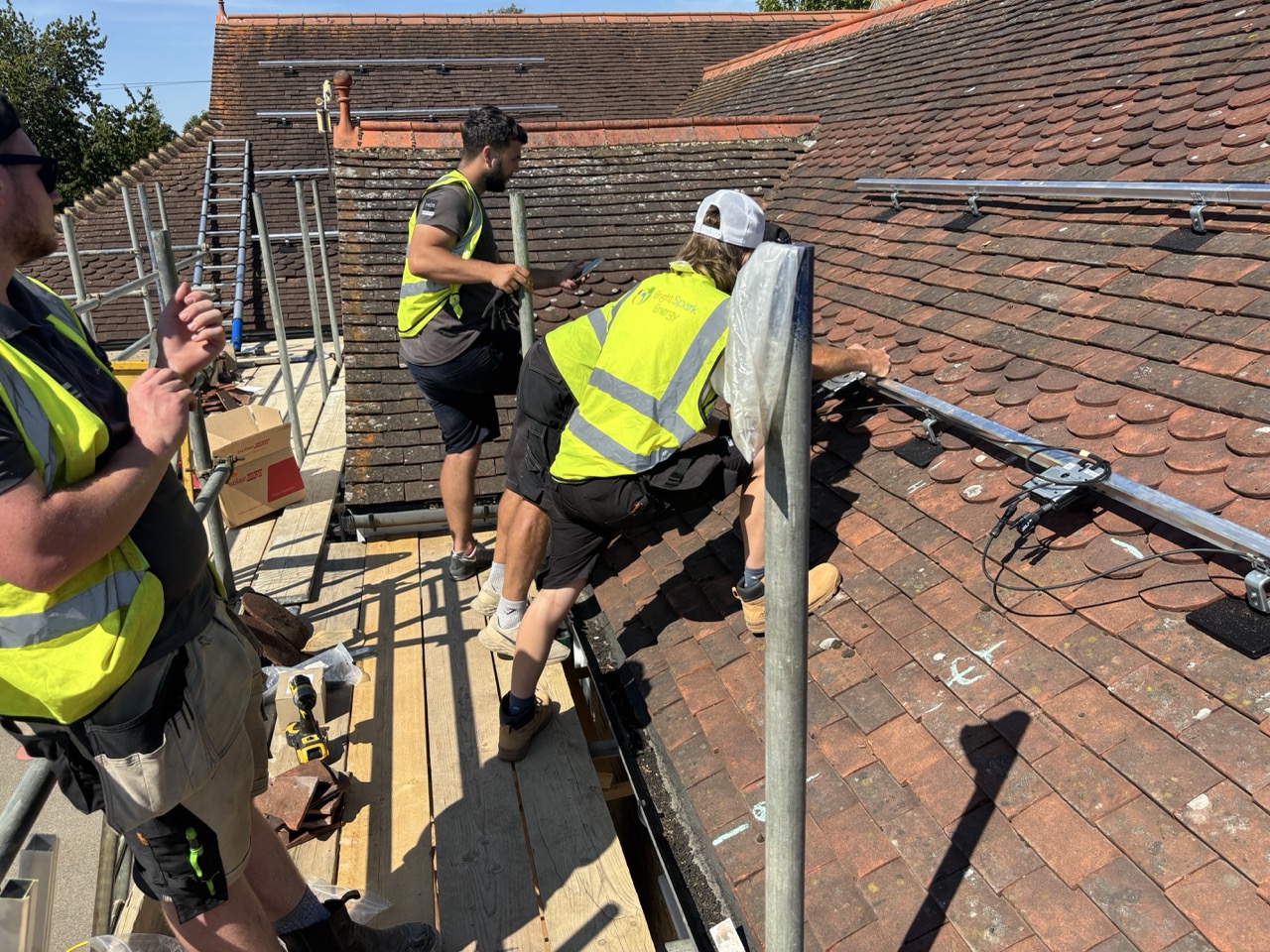 Bright Spark engineers fitting solar mounting rails on a tiled roof